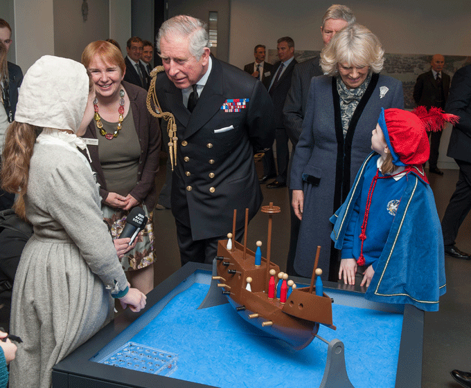 Prince Charles and the Duchess of Cornwall talk to children in period dress at the Mary Rose exhibition