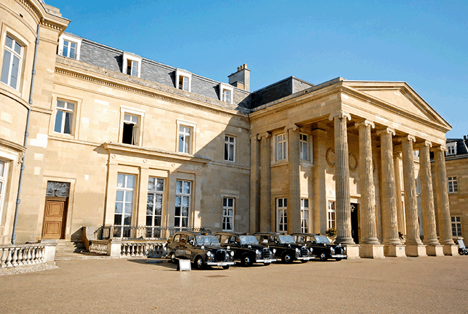 Taxis line up outside the front entrance to Luton Hoo, Bedfordshire