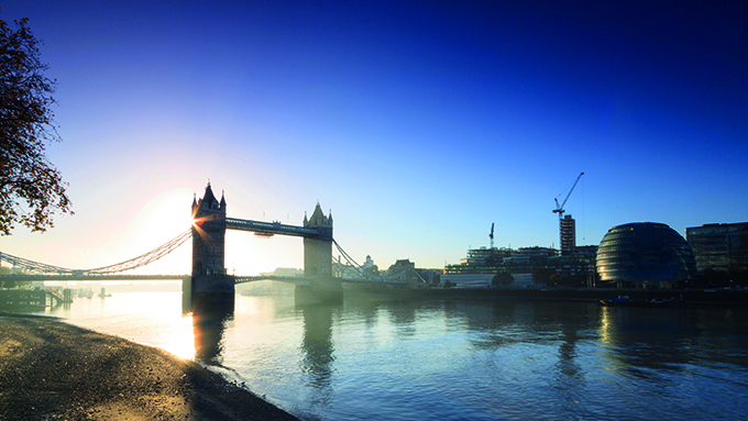 The sun rises behind Tower Bridge, on the Thames, London. Ancient history of London, Britain
